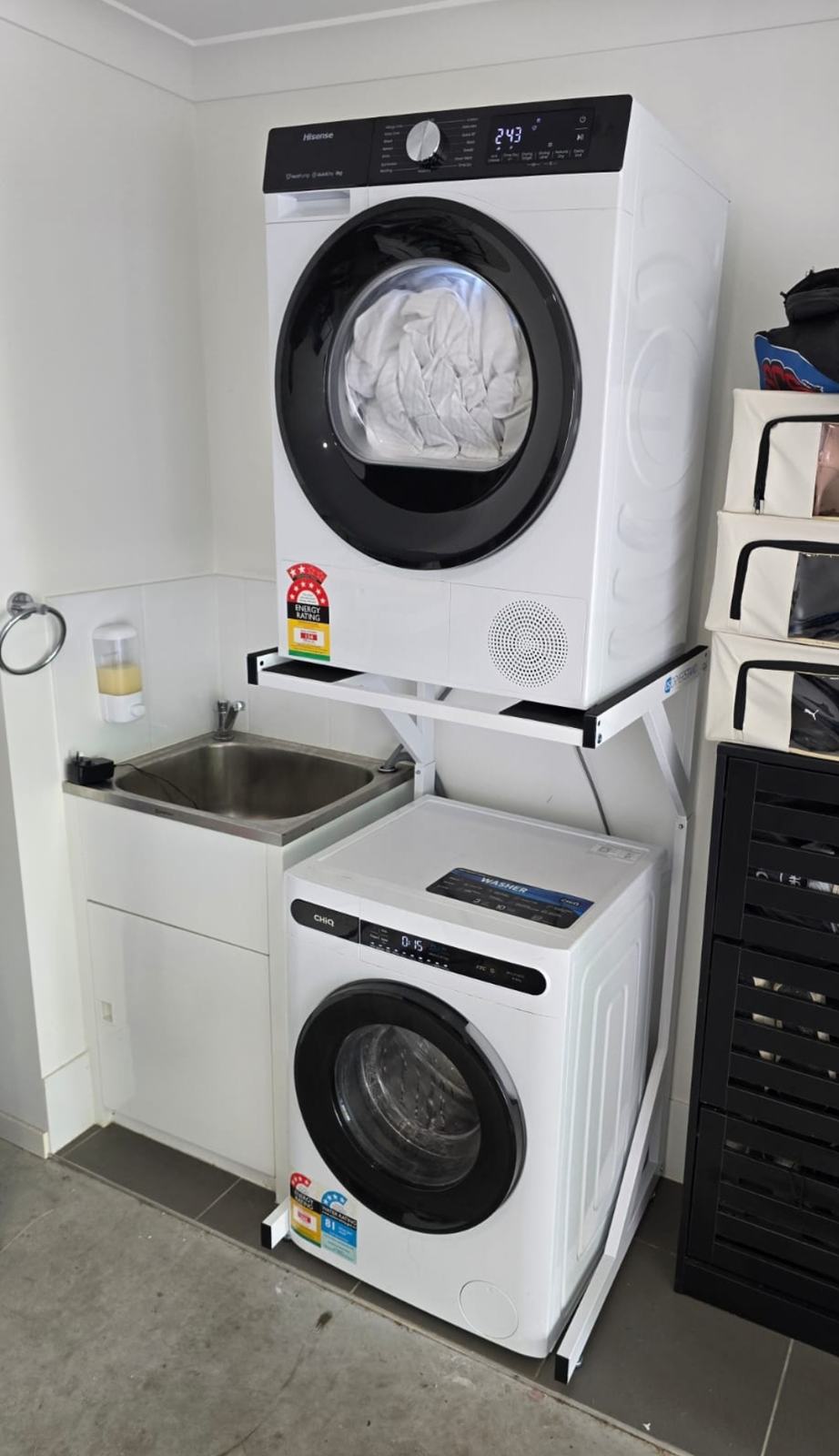 Real Space DryerStand Adjustable showing a DryerStand freestanding tumble dryer stand in a real laundry space with a dryer above a washing machine