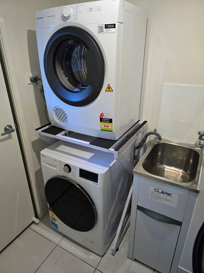 Real Space DryerStand Adjustable showing a DryerStand freestanding tumble dryer stand in a real laundry space with a dryer above a washing machine