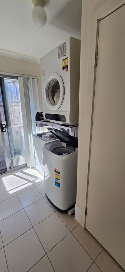 Real Space DryerStand Adjustable showing a DryerStand freestanding tumble dryer stand in a real laundry space with a dryer above a washing machine