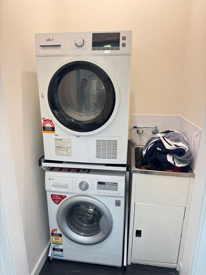 Real Space DryerStand Maxi showing a DryerStand freestanding tumble dryer stand in a real laundry space with a dryer above a washing machine