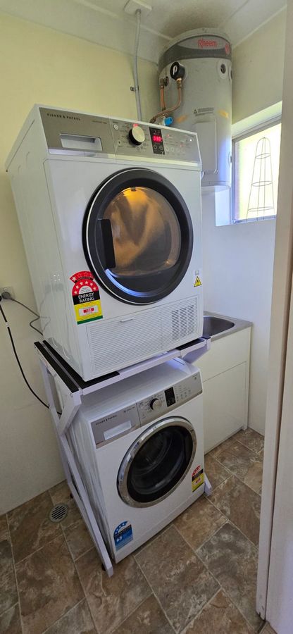 Real Space DryerStand Maxi showing a DryerStand freestanding tumble dryer stand in a real laundry space with a dryer above a washing machine