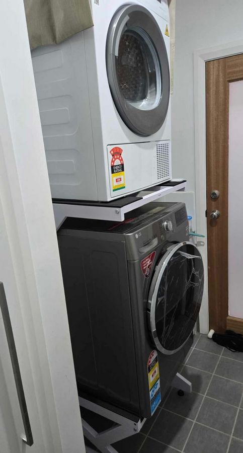 Real Space DryerStand Maxi showing a DryerStand freestanding tumble dryer stand in a real laundry space with a dryer above a washing machine