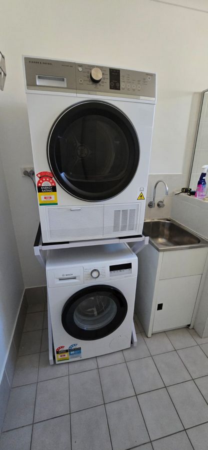 Real Space DryerStand Maxi showing a DryerStand freestanding tumble dryer stand in a real laundry space with a dryer above a washing machine