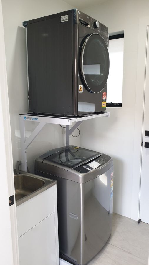 Real Space DryerStand Adjustable showing a DryerStand freestanding tumble dryer stand in a real laundry space with a dryer above a washing machine