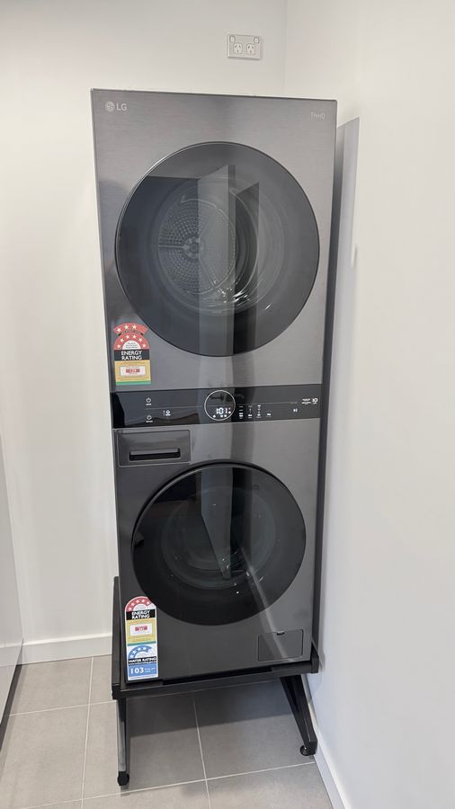 Real Space DryerStand Maxi showing a DryerStand freestanding tumble dryer stand in a real laundry space with a dryer above a washing machine