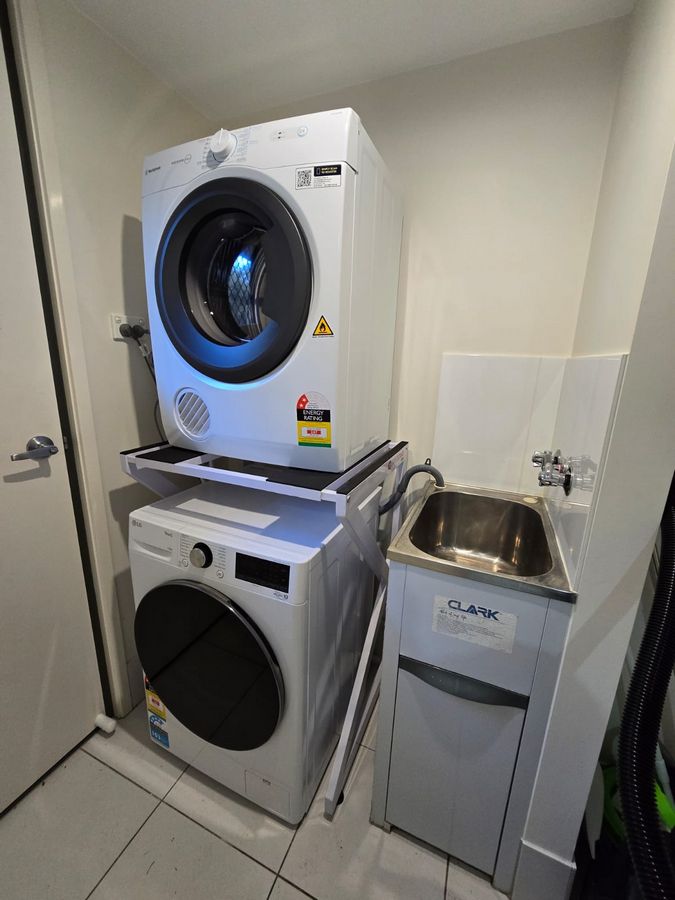 Real Space DryerStand Maxi showing a DryerStand freestanding tumble dryer stand in a real laundry space with a dryer above a washing machine