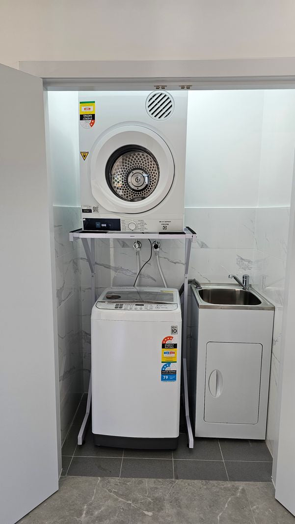Real Space DryerStand Adjustable showing a DryerStand freestanding tumble dryer stand in a real laundry space with a dryer above a washing machine