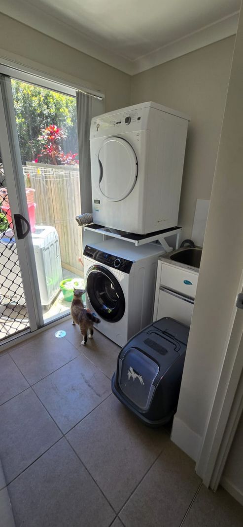 Real Space DryerStand Maxi showing a DryerStand freestanding tumble dryer stand in a real laundry space with a dryer above a washing machine