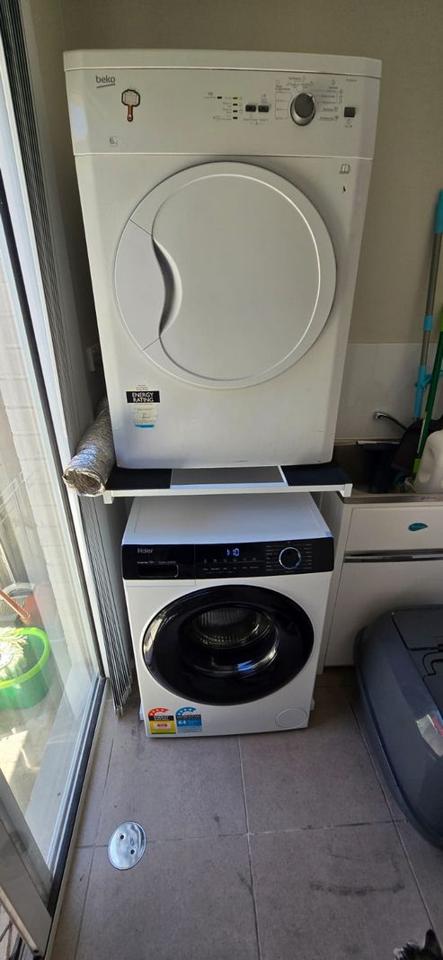 Real Space DryerStand Maxi showing a DryerStand freestanding tumble dryer stand in a real laundry space with a dryer above a washing machine