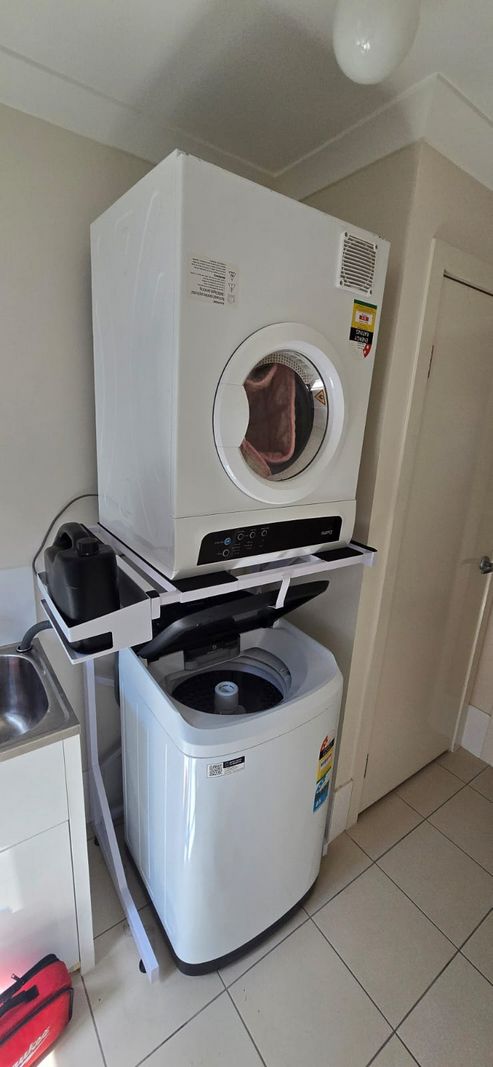 Real Space DryerStand Adjustable showing a DryerStand freestanding tumble dryer stand in a real laundry space with a dryer above a washing machine