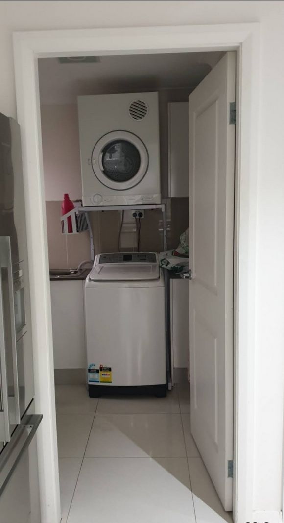 Real Space DryerStand Maxi showing a DryerStand freestanding tumble dryer stand in a real laundry space with a dryer above a washing machine