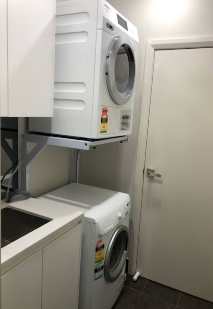 Real Space DryerStand Adjustable showing a DryerStand freestanding tumble dryer stand in a real laundry space with a dryer above a washing machine
