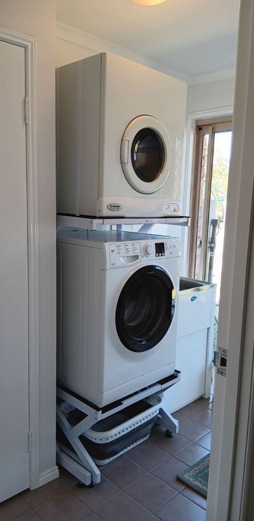 Real Space DryerStand Adjustable showing a DryerStand freestanding tumble dryer stand in a real laundry space with a dryer above a washing machine
